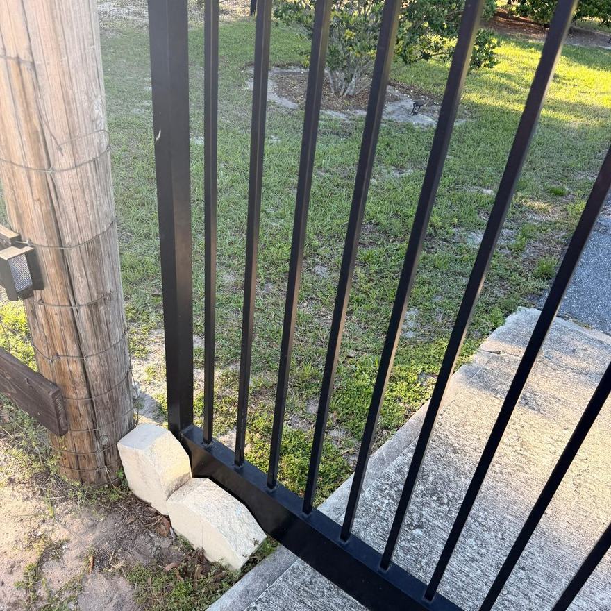 Black aluminum side gate installed alongside a home