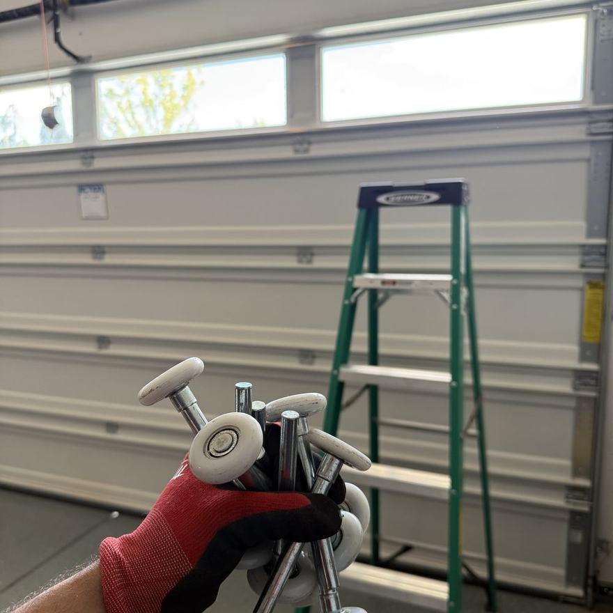 Worn steel garage door rollers replaced with quiet nylon rollers